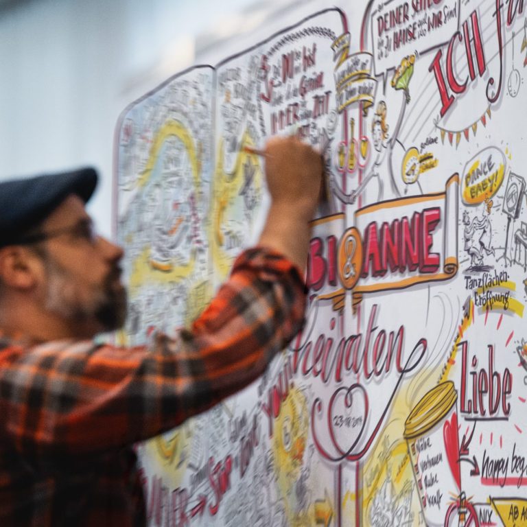Graphic Recording Foto, Illustrator Tobias Wieland beim Zeichnen eines Graphic Recording